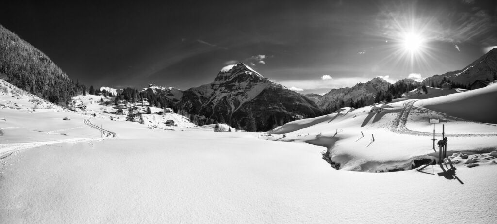 Panoramic black and white image of snow-capped alpine landscape