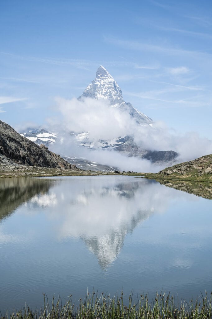 The Matterhorn mirroring into the Riffelsee on a sunny day in the Swiss alps