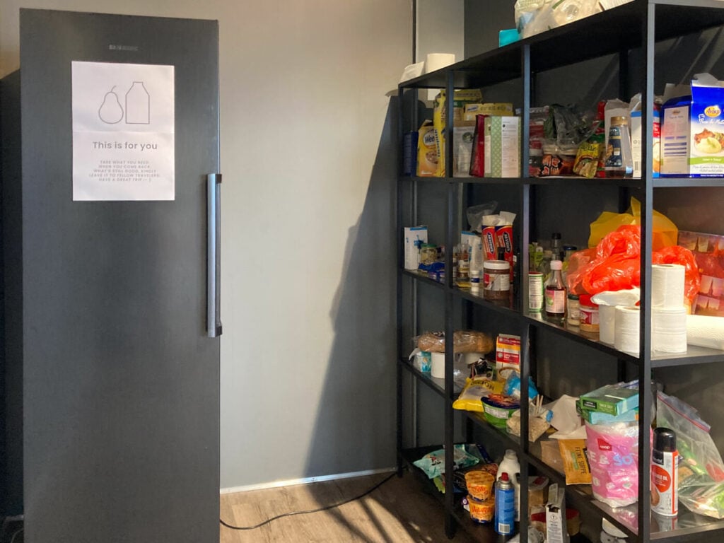 Corner with a fridge and food or free groceries at a van rental station.