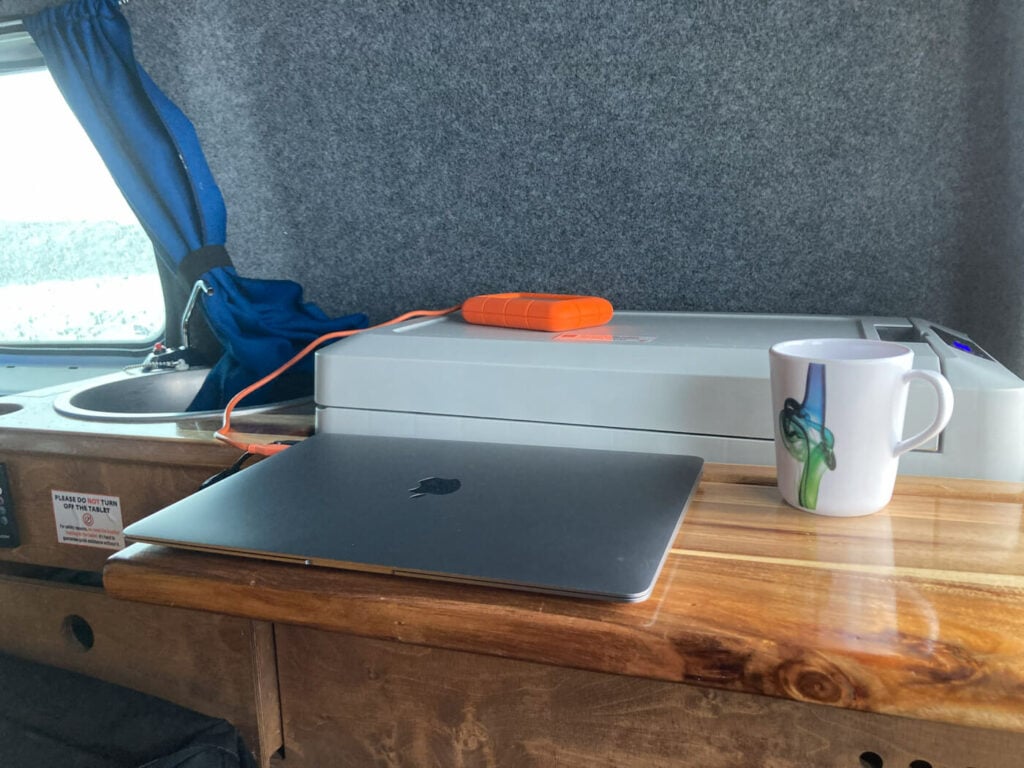 Laptop on a table in a camp easy easy small caddy campervan used during a ring road trip in Iceland.