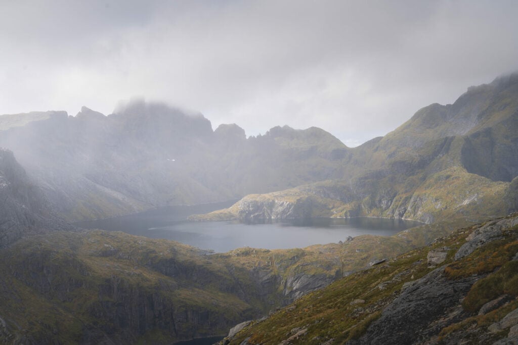 light and rain interplay above a lake in the lofoten islands
