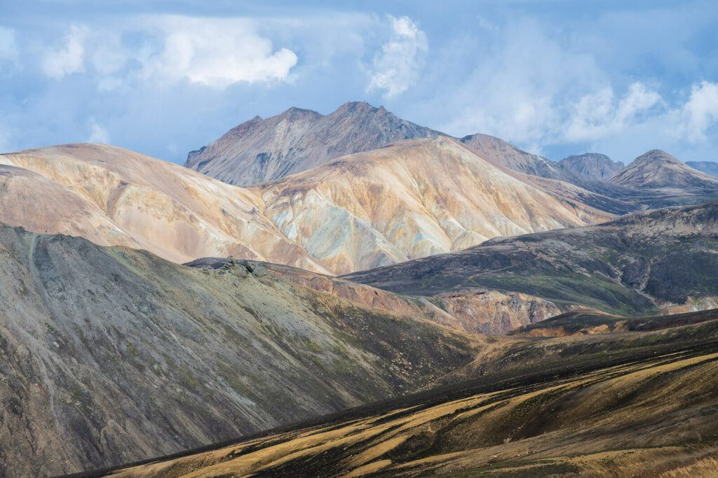 multiple layers of colorful mountains on a sunny day in landmannalaugar