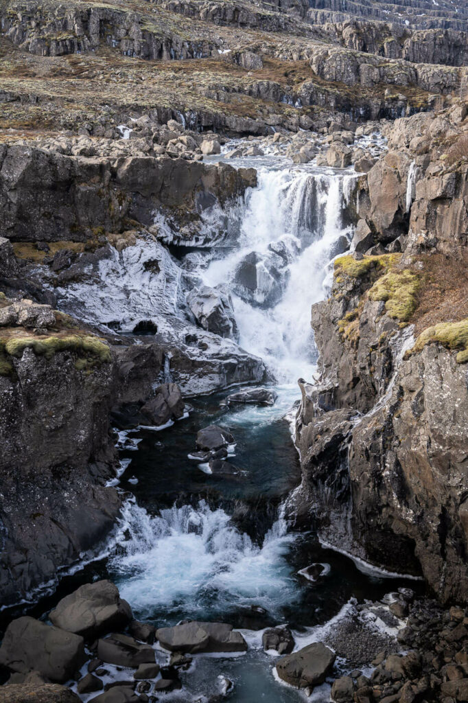 Nykurhylsfoss in winter, a waterfall with ice around it.