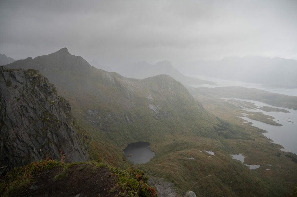 Dark clouds and rain above mountains and a fjord