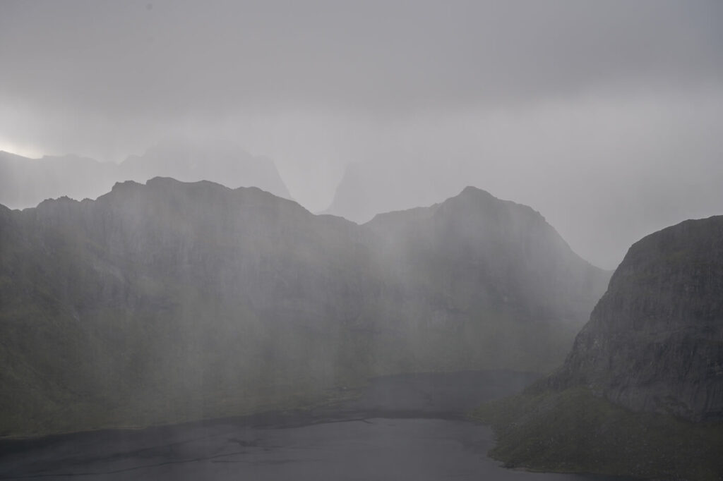 Heavy rain in the distance overlooking the mountains on the Hike to Kitinden on the lofoten islands.