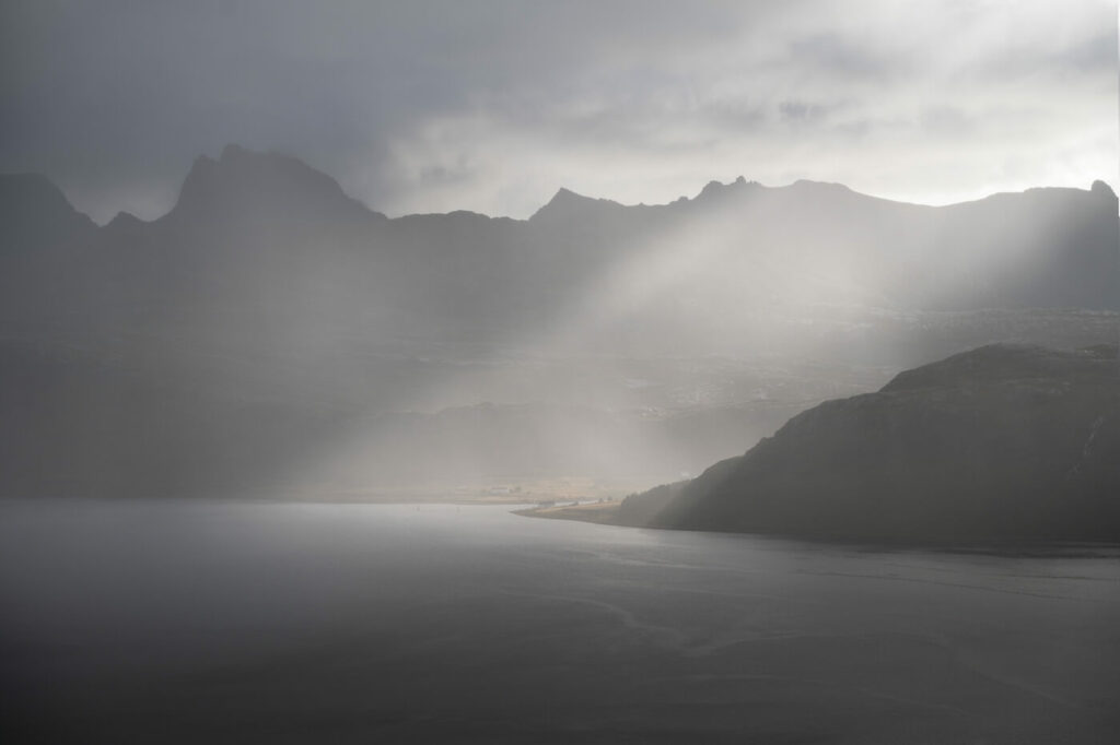 Beam of light through rain and clouds in arctic norway