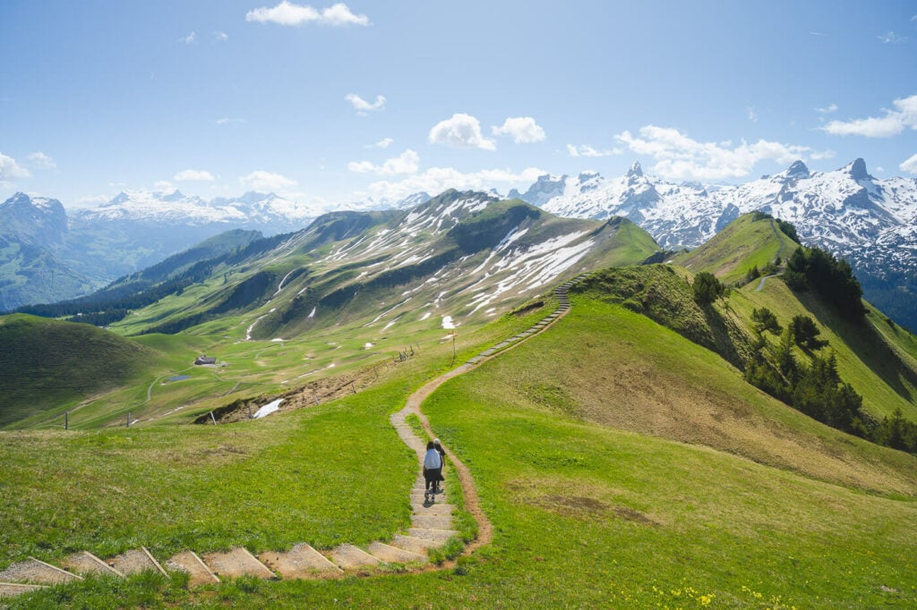 Trail on a ridge on the mountains toward Klingenstock with two hikers on a path