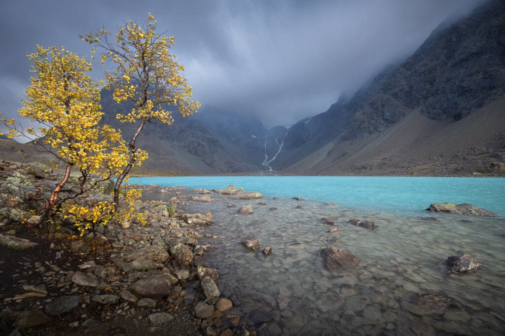 On the shores of Lake Blåisvatnet in the Lyngen Alps during a cloudy and rainy day.