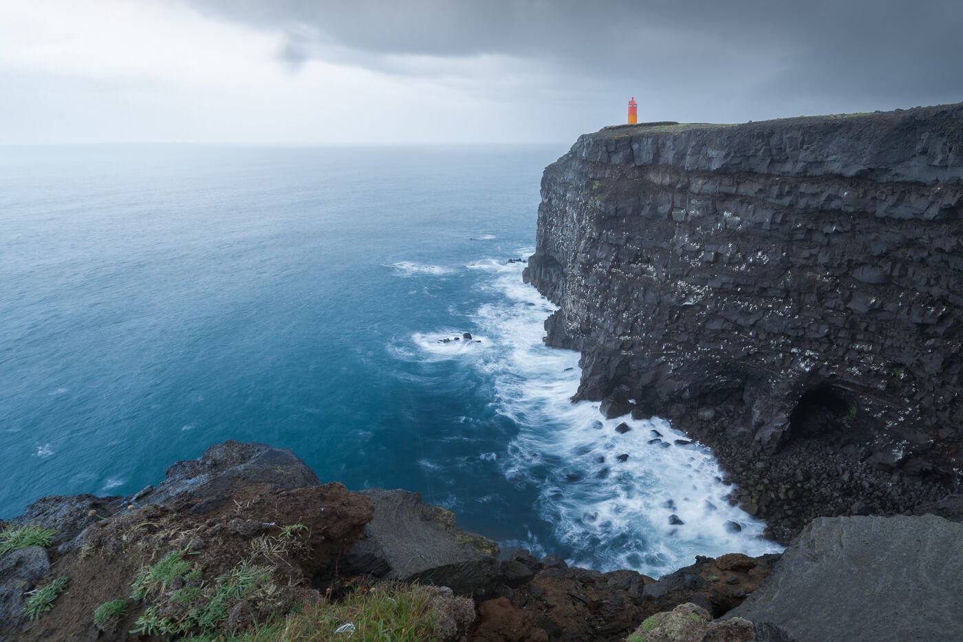 View of the Krisuvikurberg cliffs and the orange lighthouse on top of them