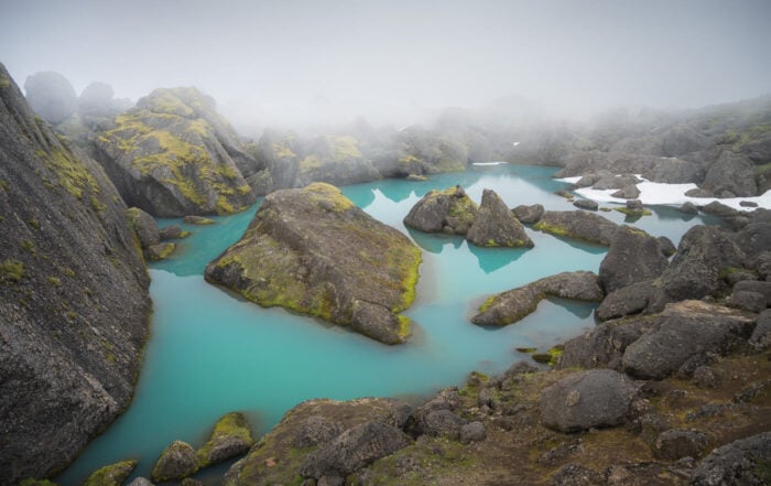 View of the giant Stórurð boulders in a small lake with Turquoise waters