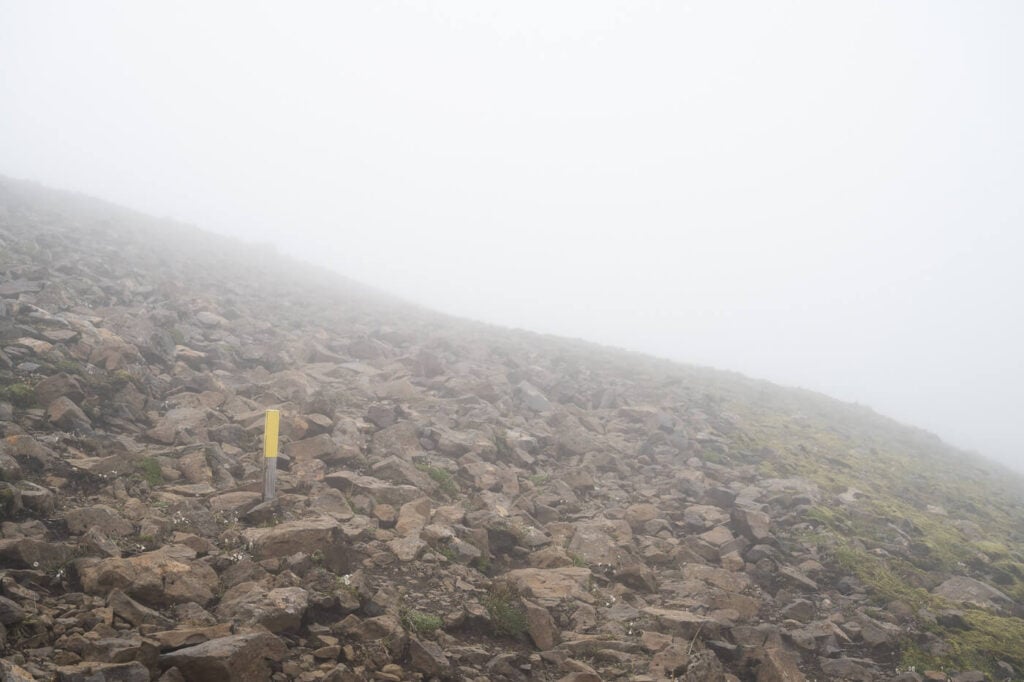 Yellow trail marker on the Stórurð hiking trail in Iceland.