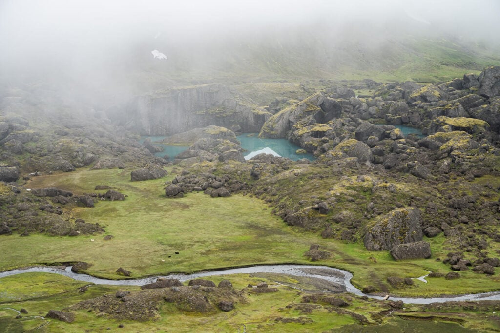 View of Stórurð from a viewpoint above the boulders and the lake on the hiking trail.