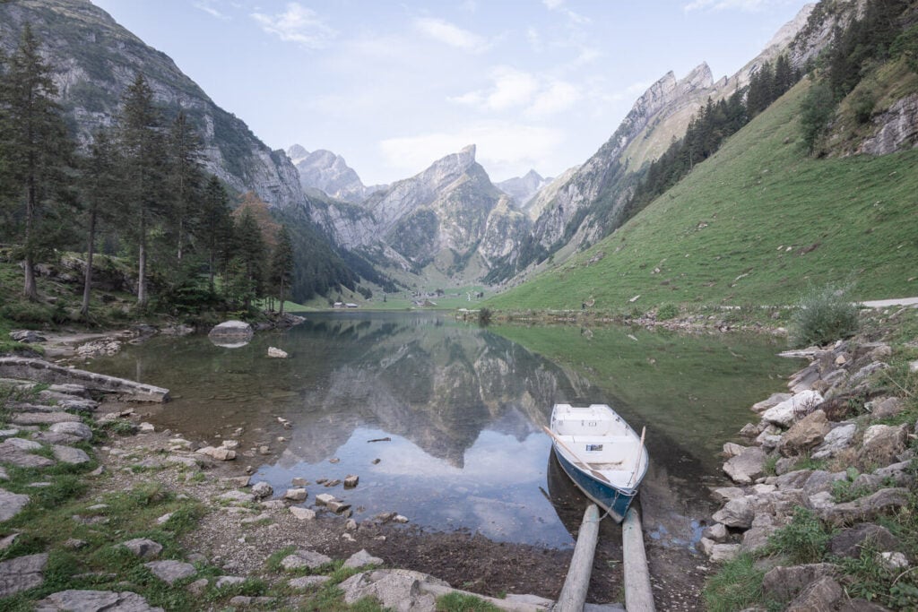 Seealpsee and a boat on its shores, with the Appenzell mountains in the background