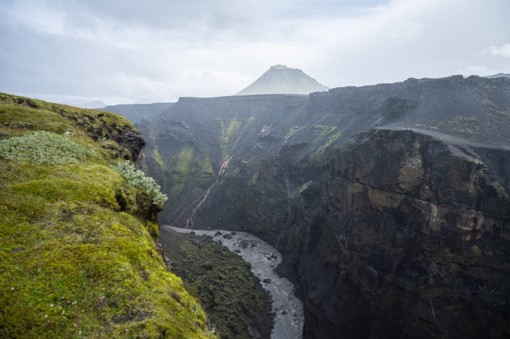 view of a bending river in a canyon in Iceland with a mountain in the background