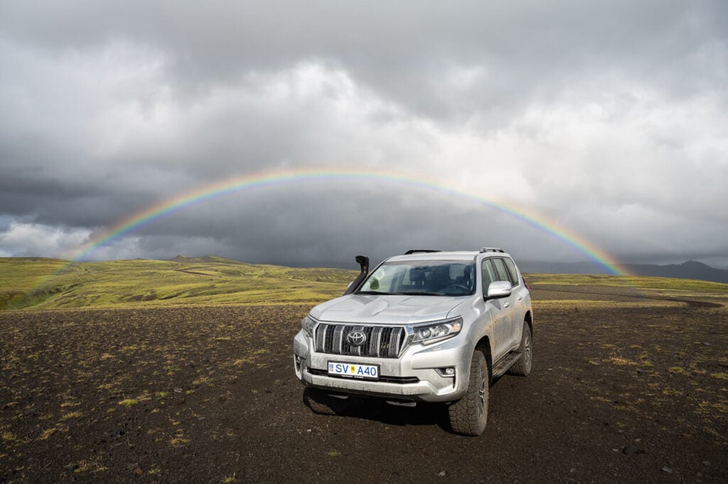 Markarfljótsgljúfur West parking with a Toyota Land Cruiser and a rainbow in the background