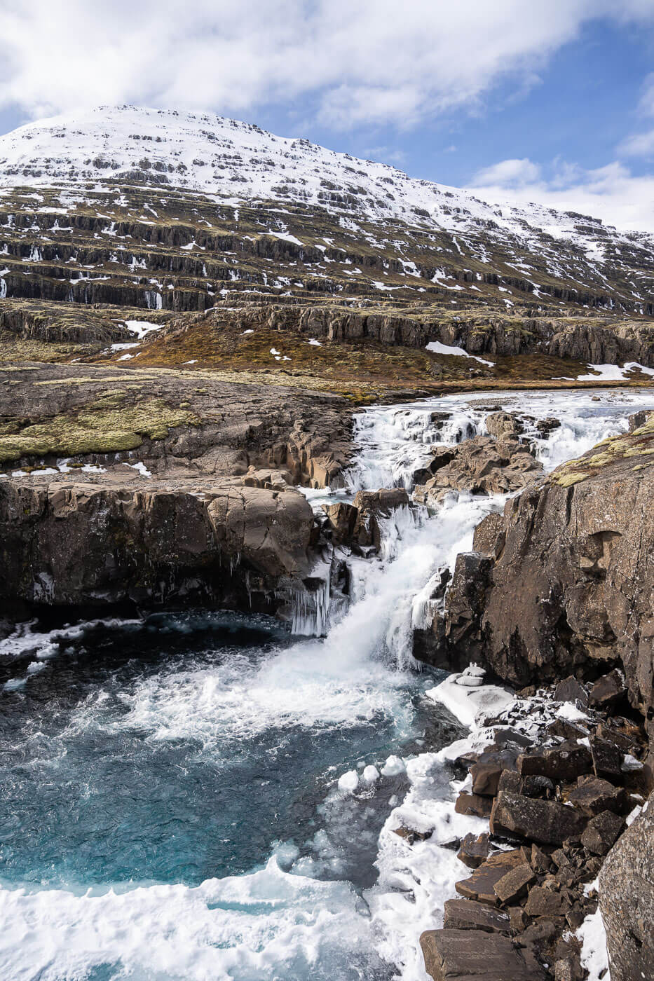 Frozen Waterfall in winter on the Fossardalur hiking trail in Iceland.