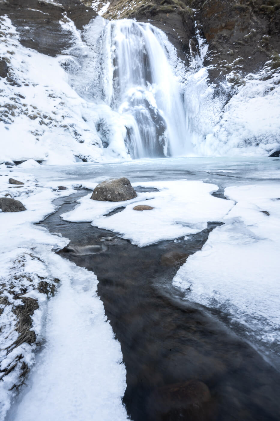 Helgufoss a waterfall in Iceland on the Laxness Hiking trail, photographer in winter in March,