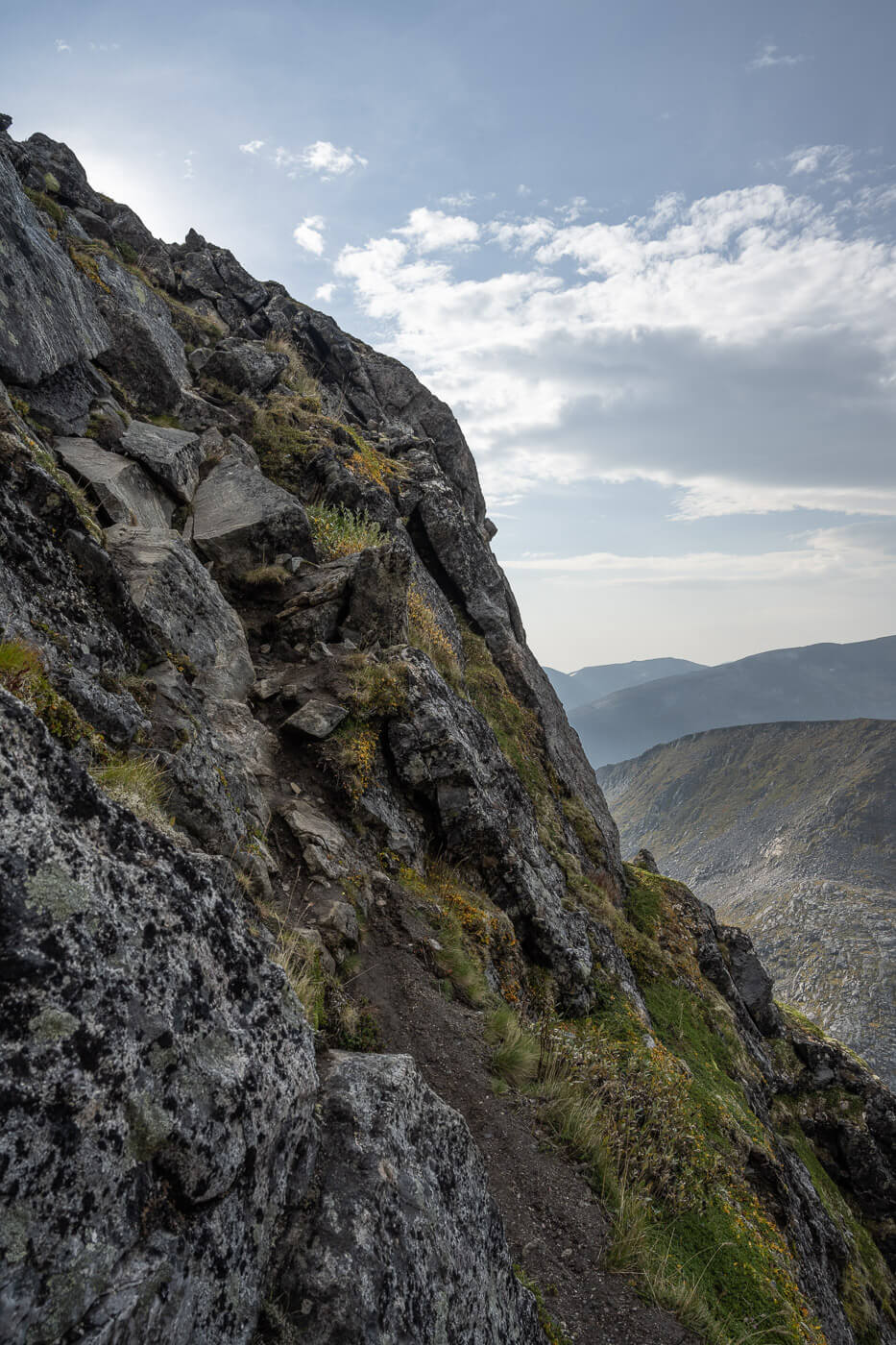 Steep and narrow hiking trail on the side of a mountain.