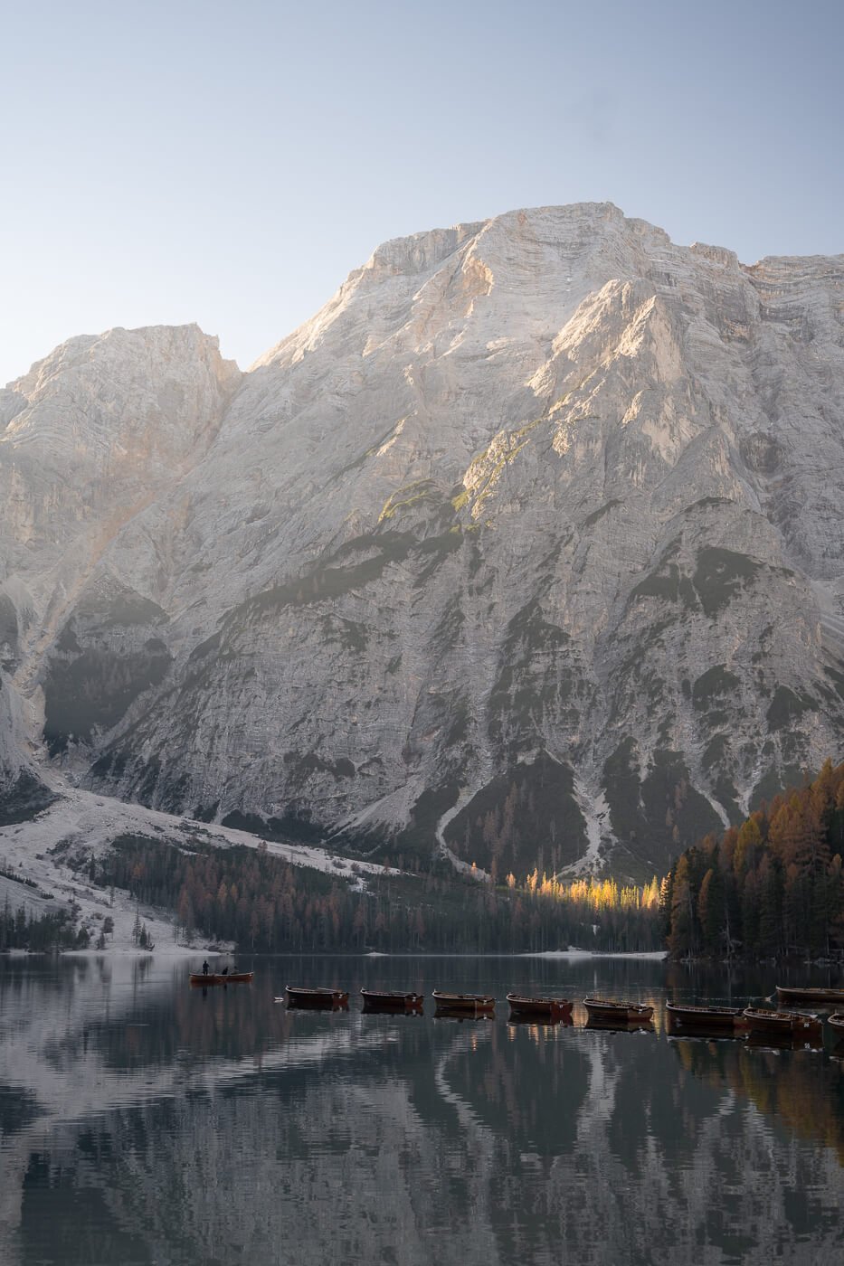 Croda del becco towering above lago di braines under a clear sky.