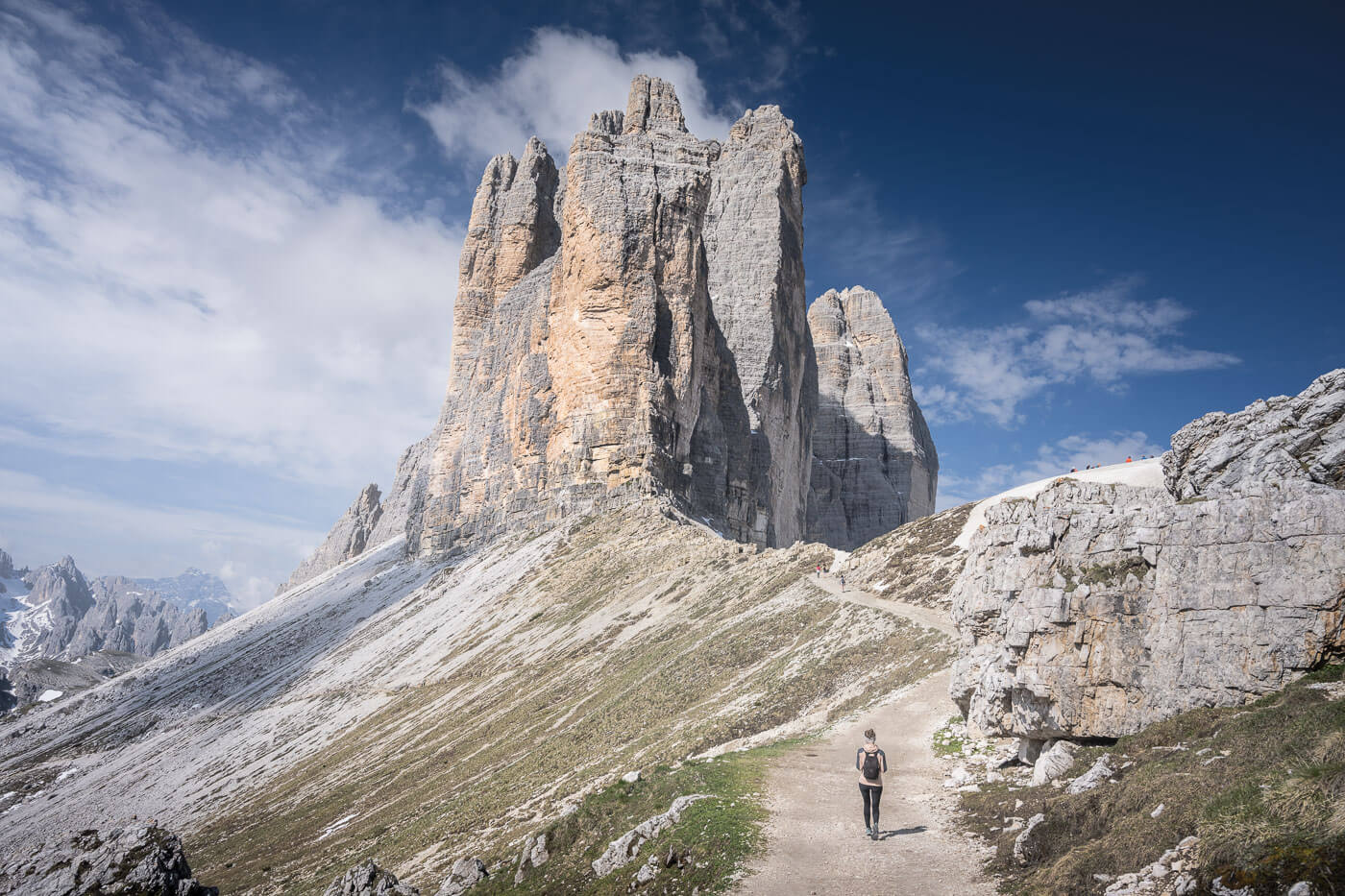 Solo hiker on a hike to le Tre Cime di Lavaredo on a sunny day with blue skies.