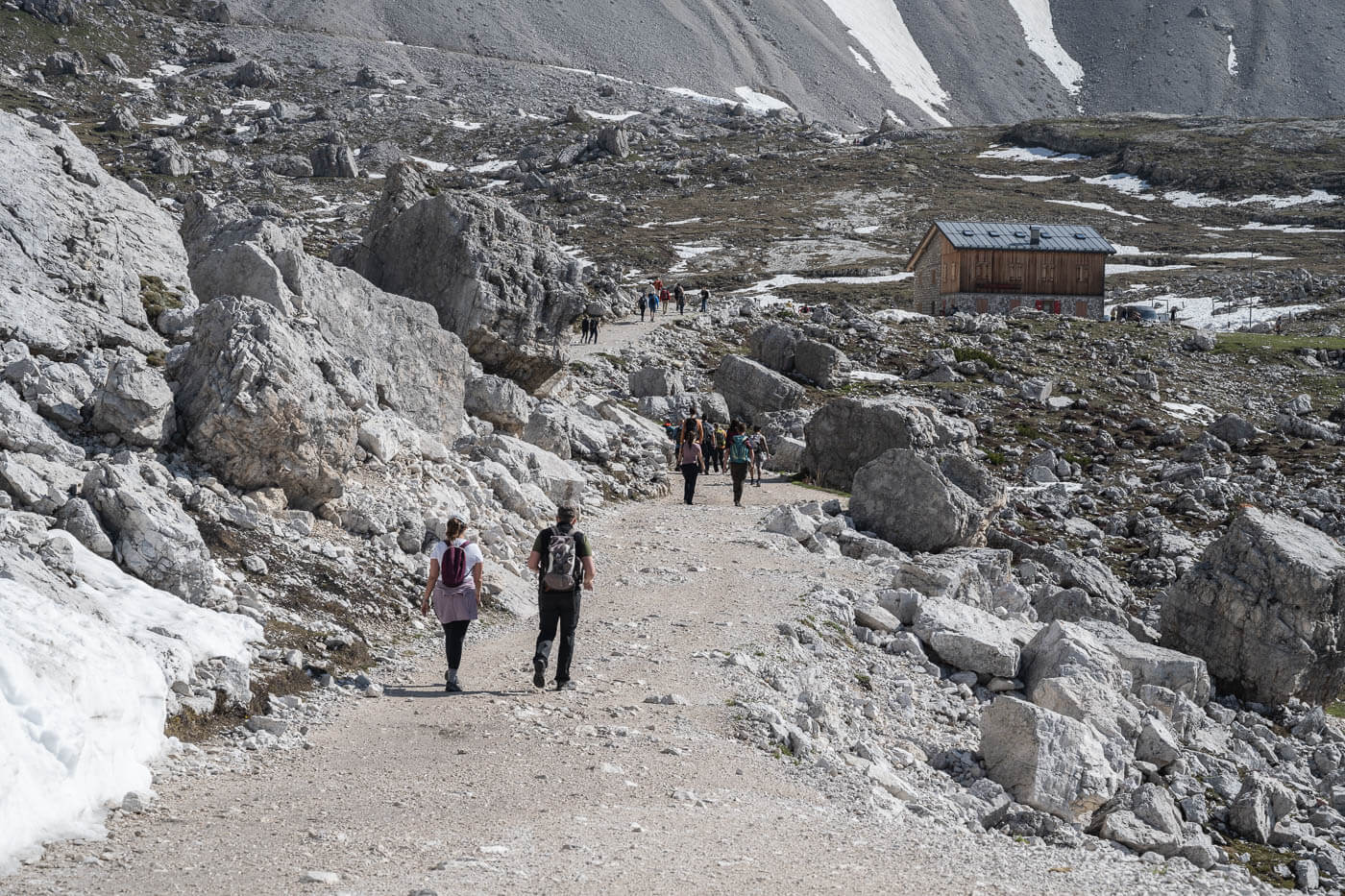 Hikers on a gravel road in the dolomites