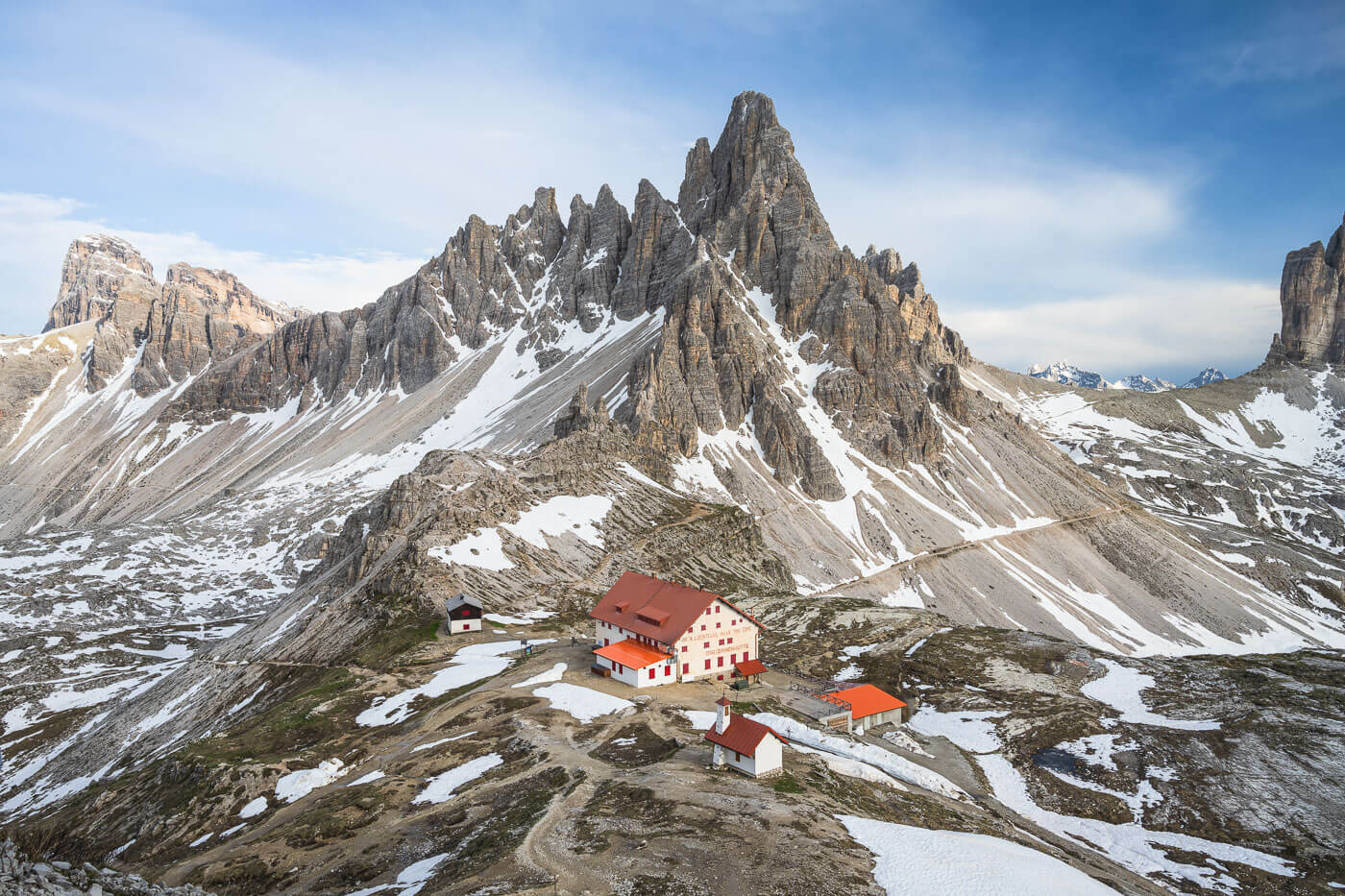 View of Rifugio Locatelli with Monte Paterno in the Background, with still snow snow on the ground.