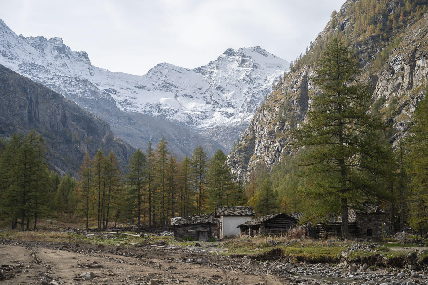 Huts in Valnontey within the Gran Paradiso with snow-capped mountains in the background.