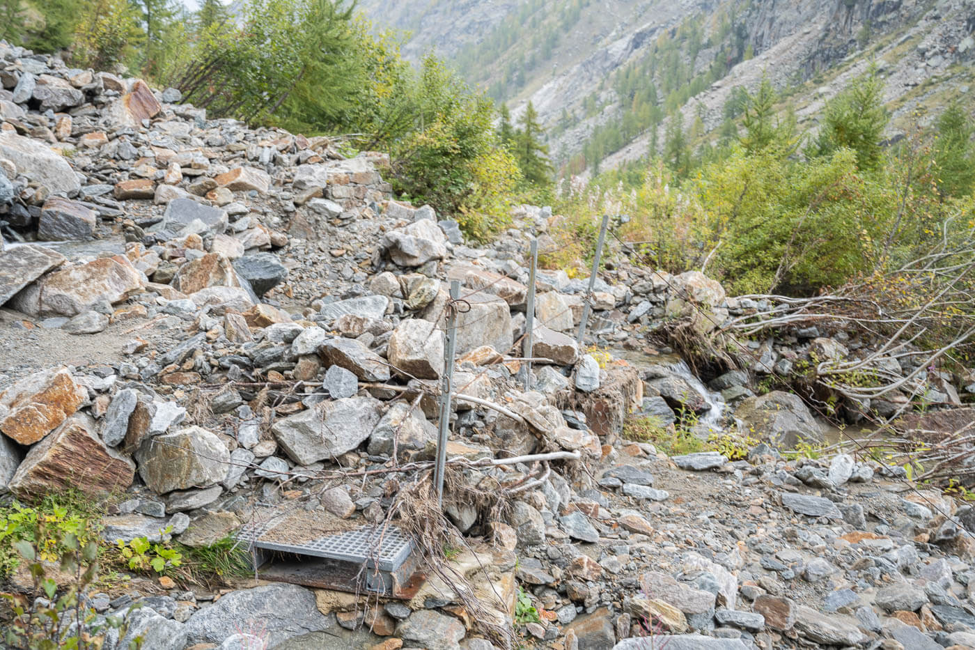 Footbridge covered in debris the fell form the mountain in Valnontey.