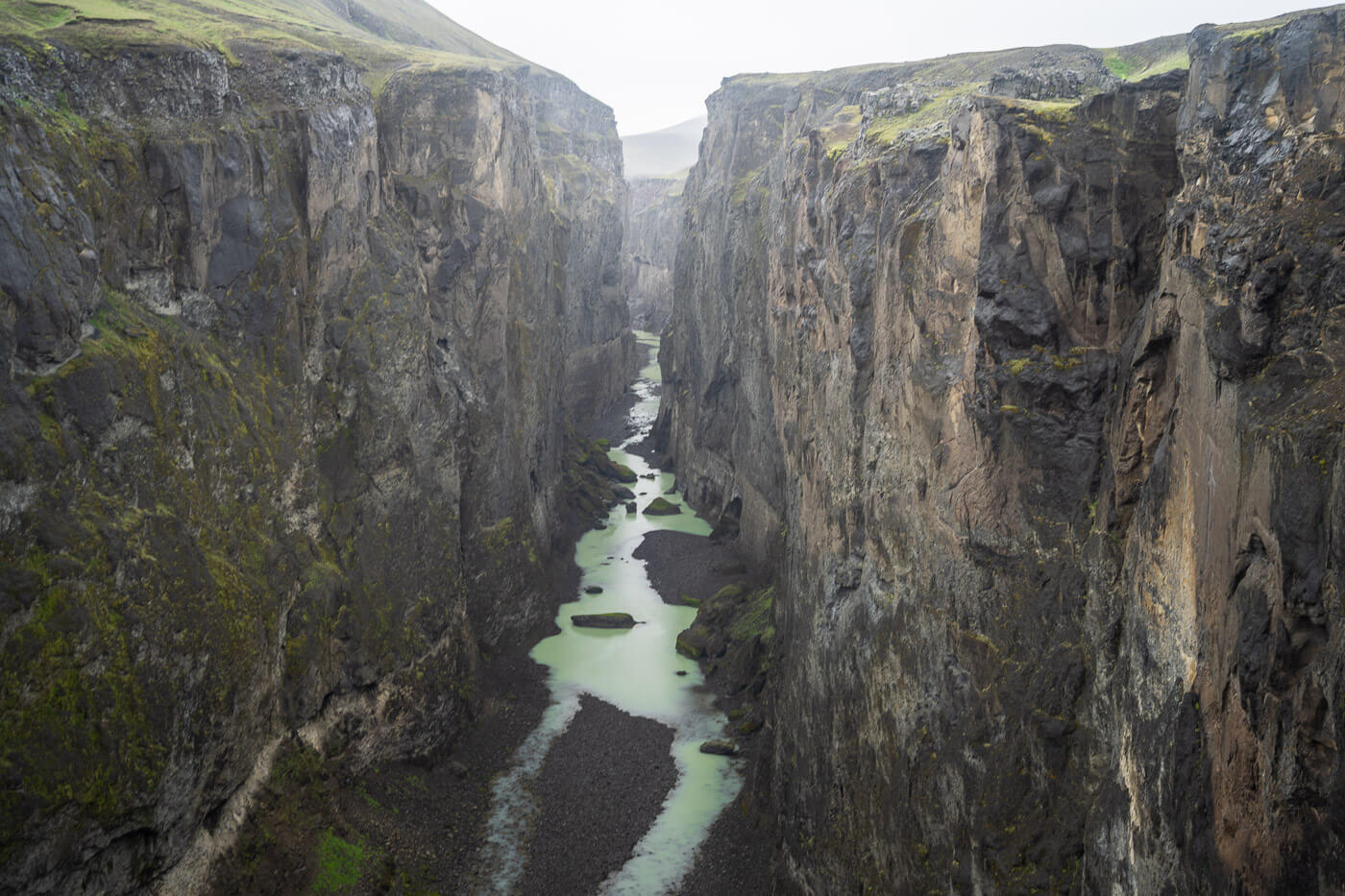 Hafrahvammagljufur' Canyon viewpoint with steep vertical cliffs and a river in between.
