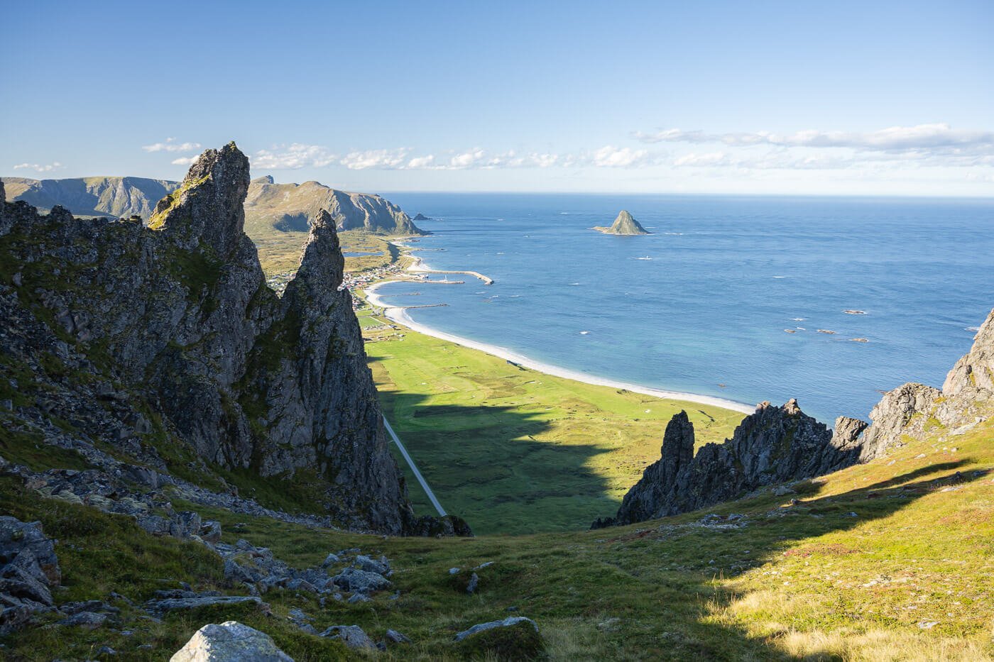 Landscape of Northern Norway on a sunny day with the sea visible in the distance.