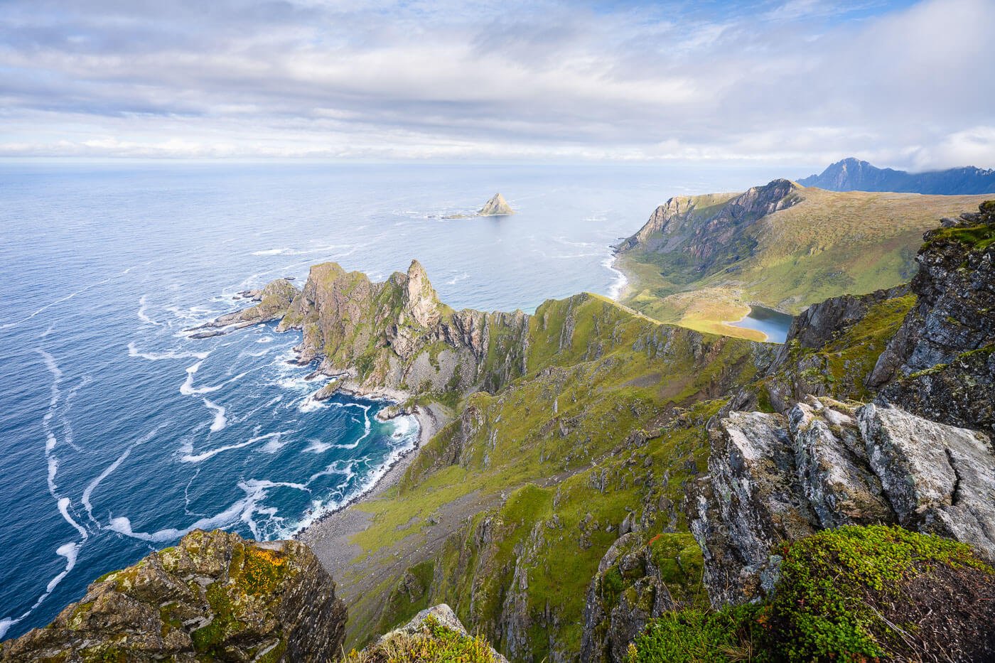 View from the top of Måtinden, the main hiking attraction in Andøya, on a partially cloudy day, in the morning sun.