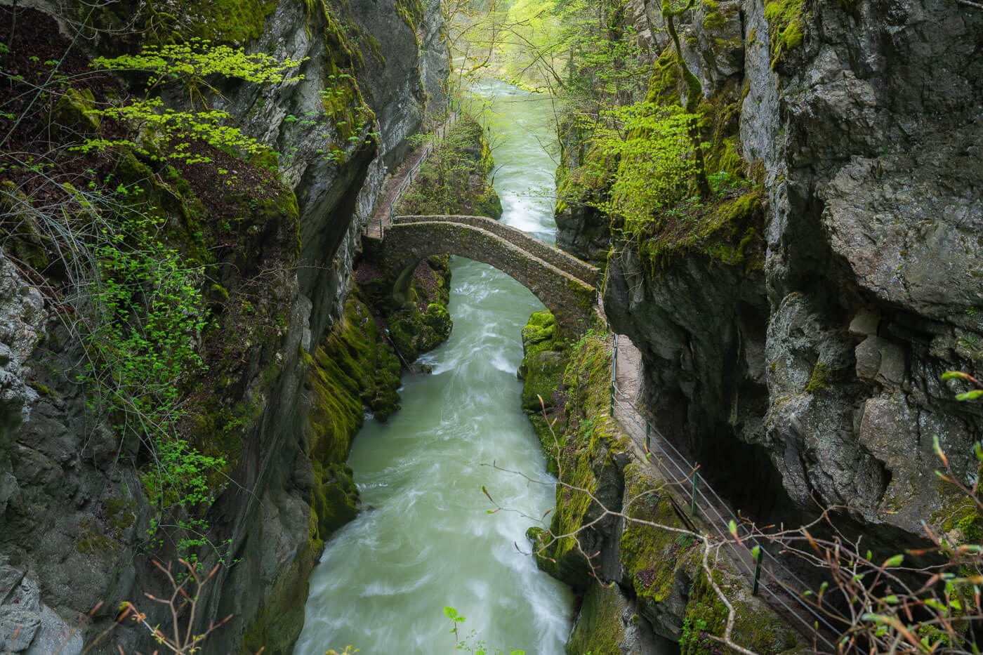 View of a stone arch bridge above gorges de l'Areuse.