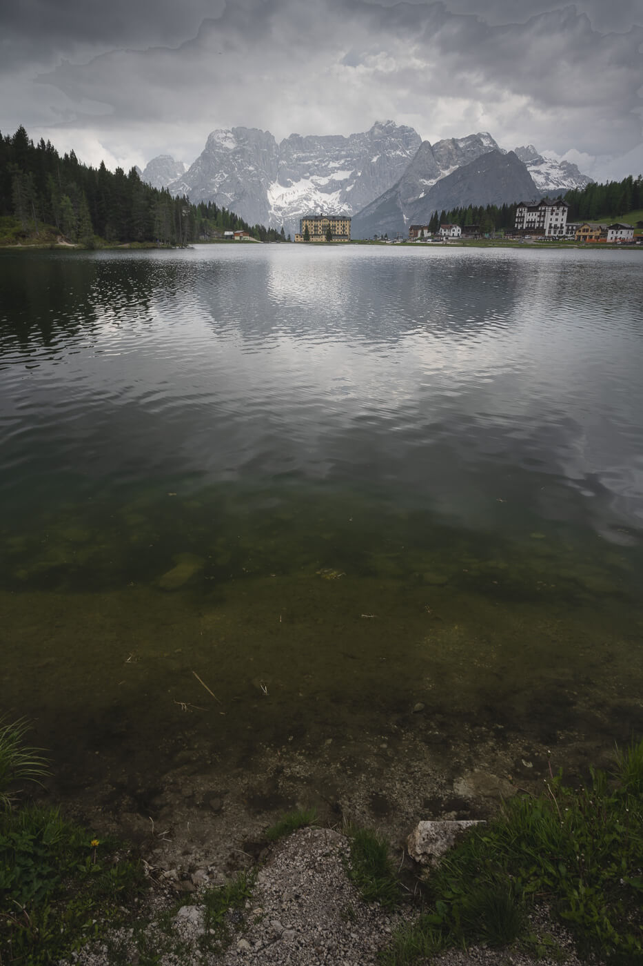 View of Lago di Misurina with a building standing along in the background again the mountains.