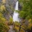 VIew of one of le Cascate di Lillaz surrounded by foliage in fall colors.