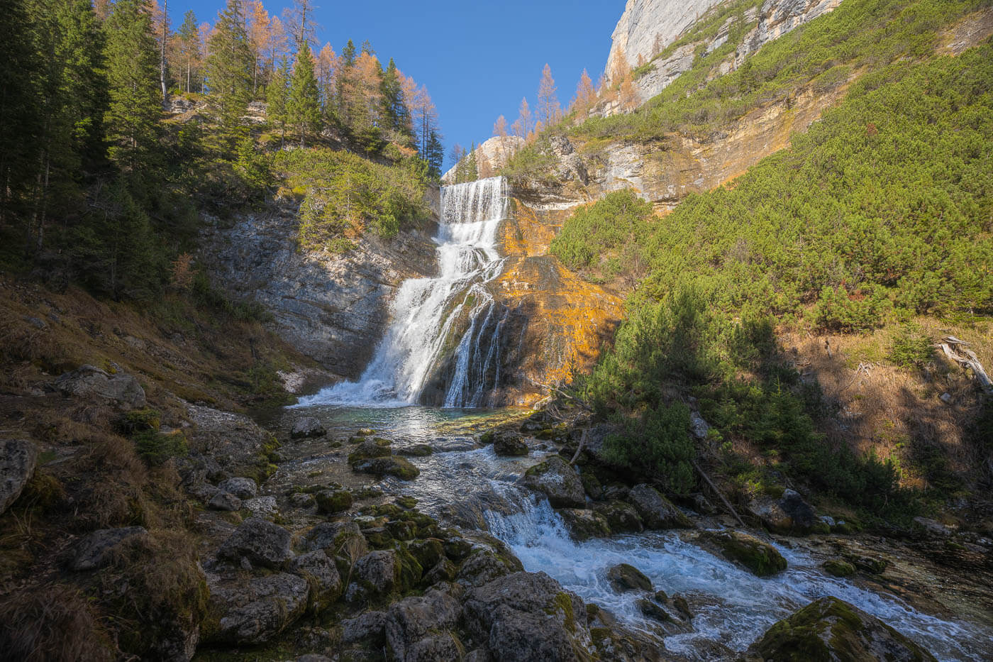 View of one of the Cascate di Fanes in autumn, a series of waterfalls you can only hike to in the dolomites.