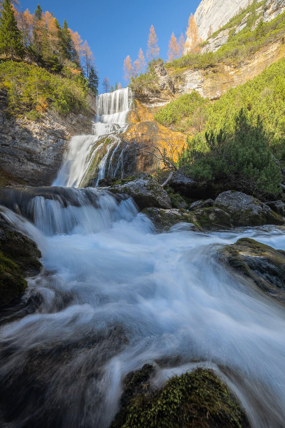 Vertical image of a three-step waterfall in the Dolomites.