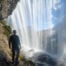 Hiker behind a waterfall of Cascated di Fanes in the Dolomites