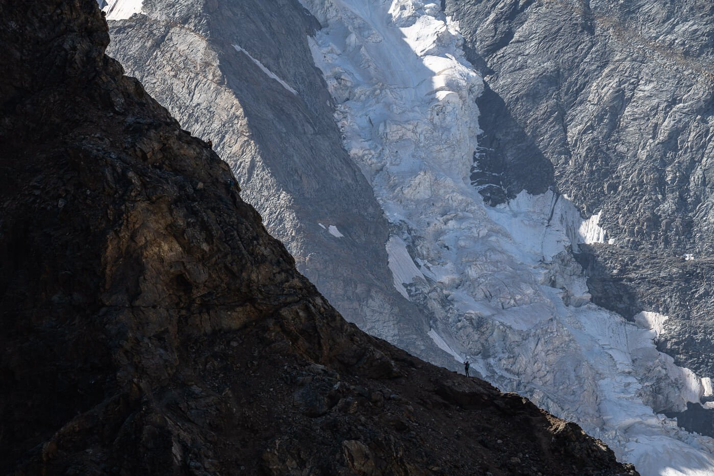 View of climbers in the distance on the Piz Trovat Via Ferrata near Diavolezza with glaciers in the background