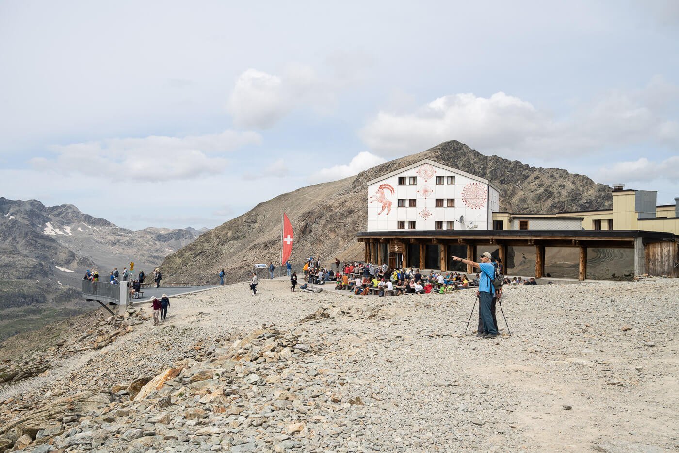 Diavolezza with tourists admiring the landscape and the Diavolezza Berggasthaus and Munt Pers in the background