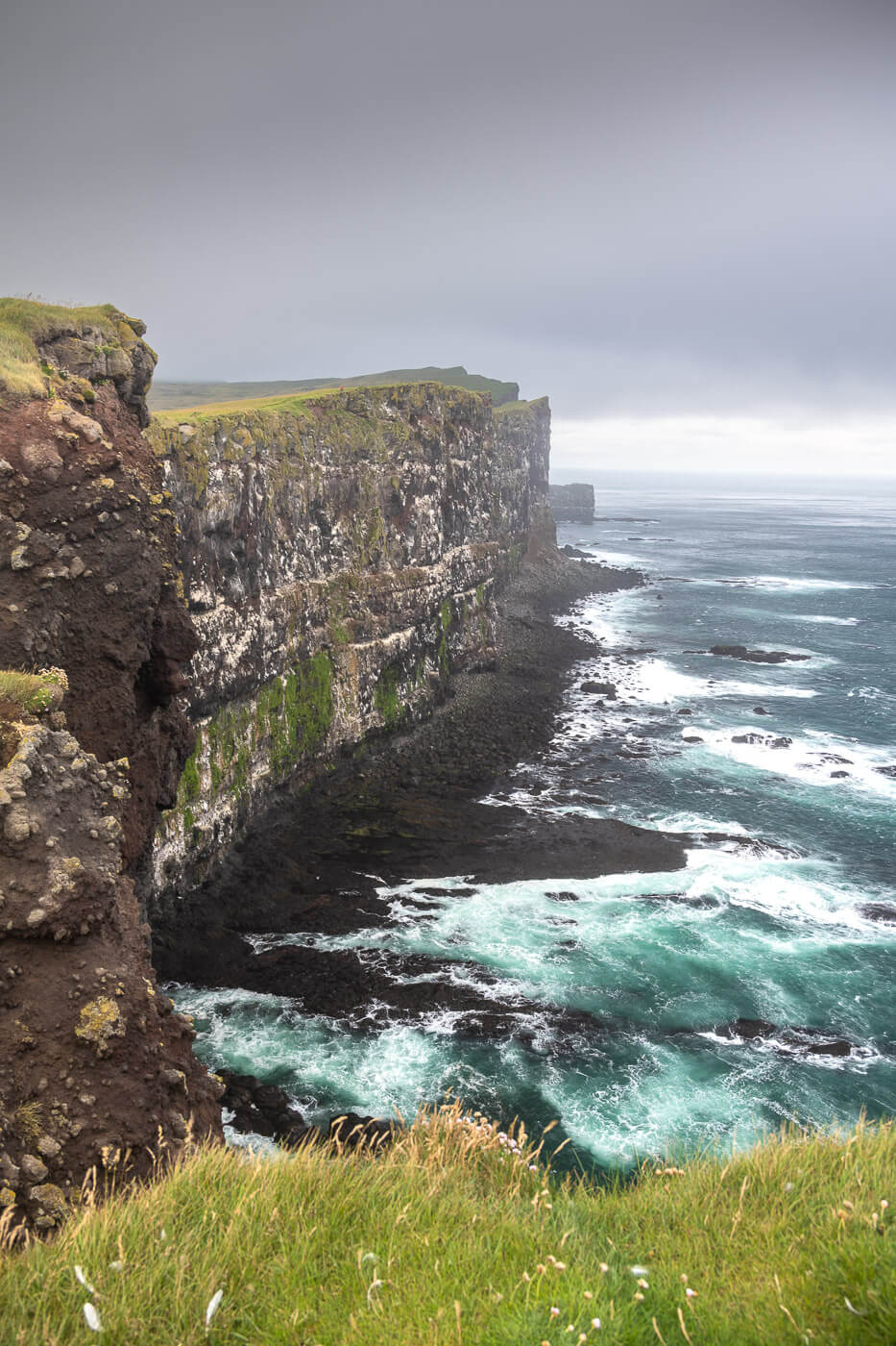Photos of sea cliffs in the westfjords of iceland, under a dark and gloomy sky.