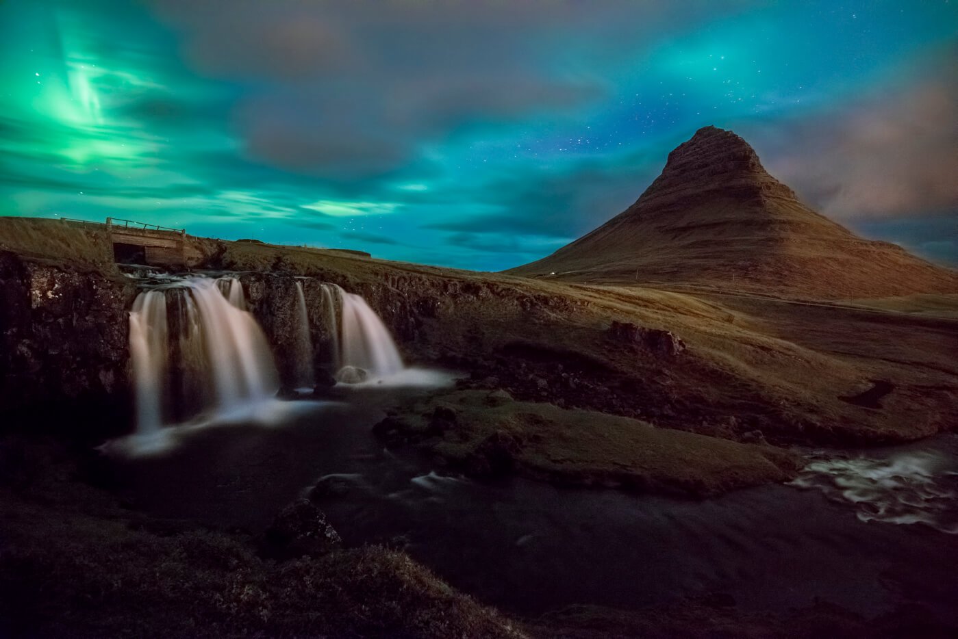 Northern lights or Aurora borealize above Kirkjufell and Kirkjufellsfoss in Iceland.