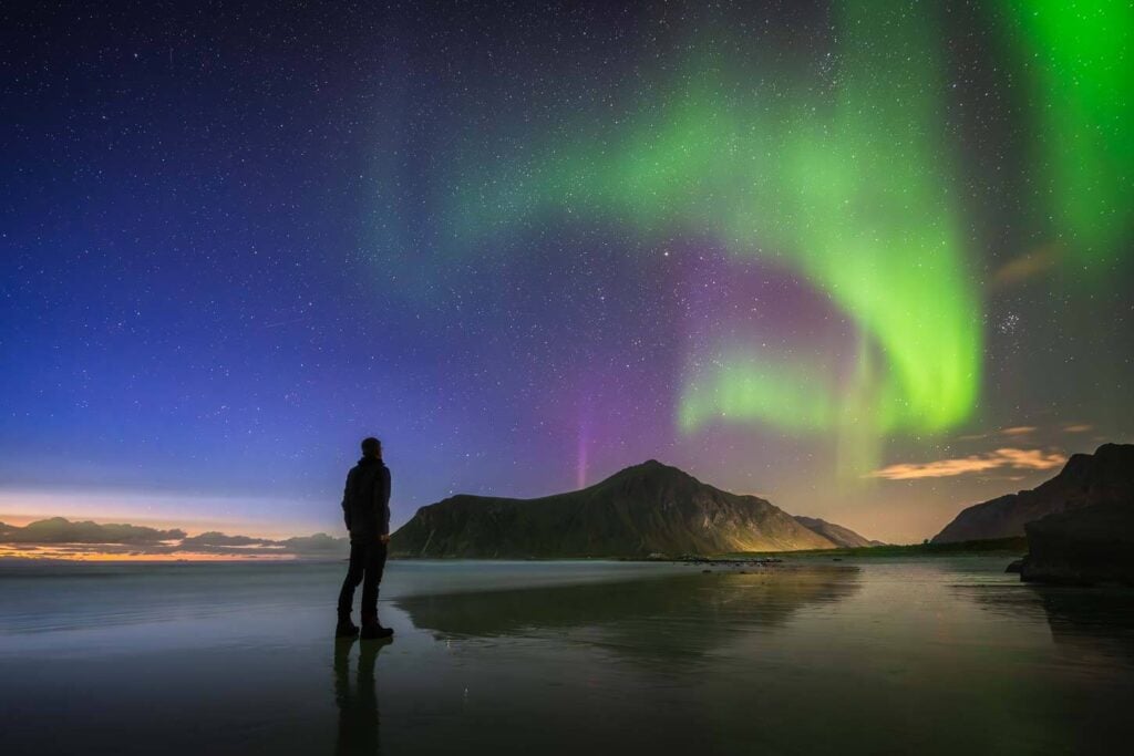 Person on a beach to see the northern lights