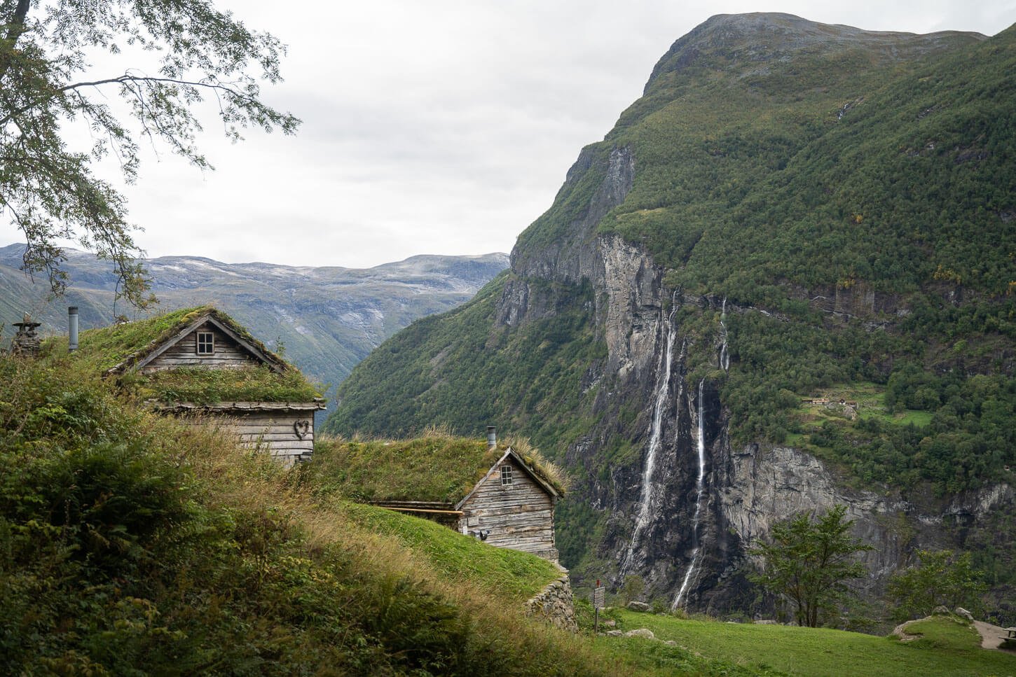 Skageflå farm viewpoint with the huts in the foreground and the seven sisters waterfalls in the background.