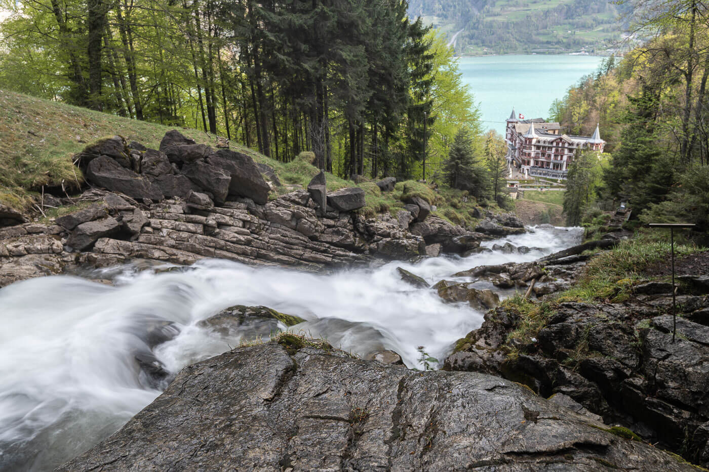 View of a small creek cascading dwon in the forest toward the hotel called Grand Hotel Giessbach in Switzerland