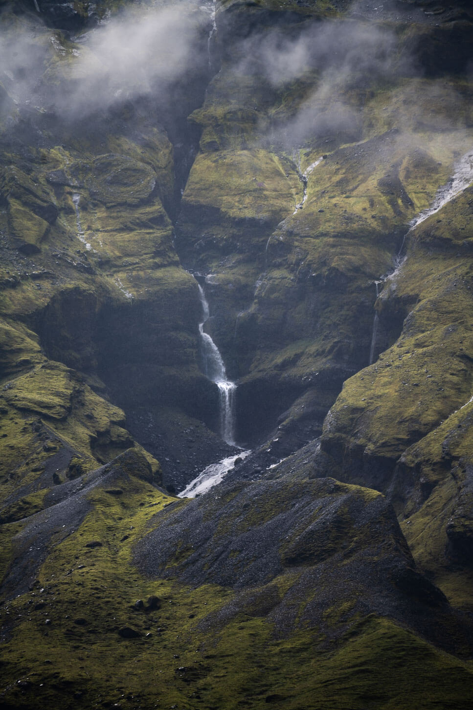 View of a waterfall in a mistly valley in Thorsmork
