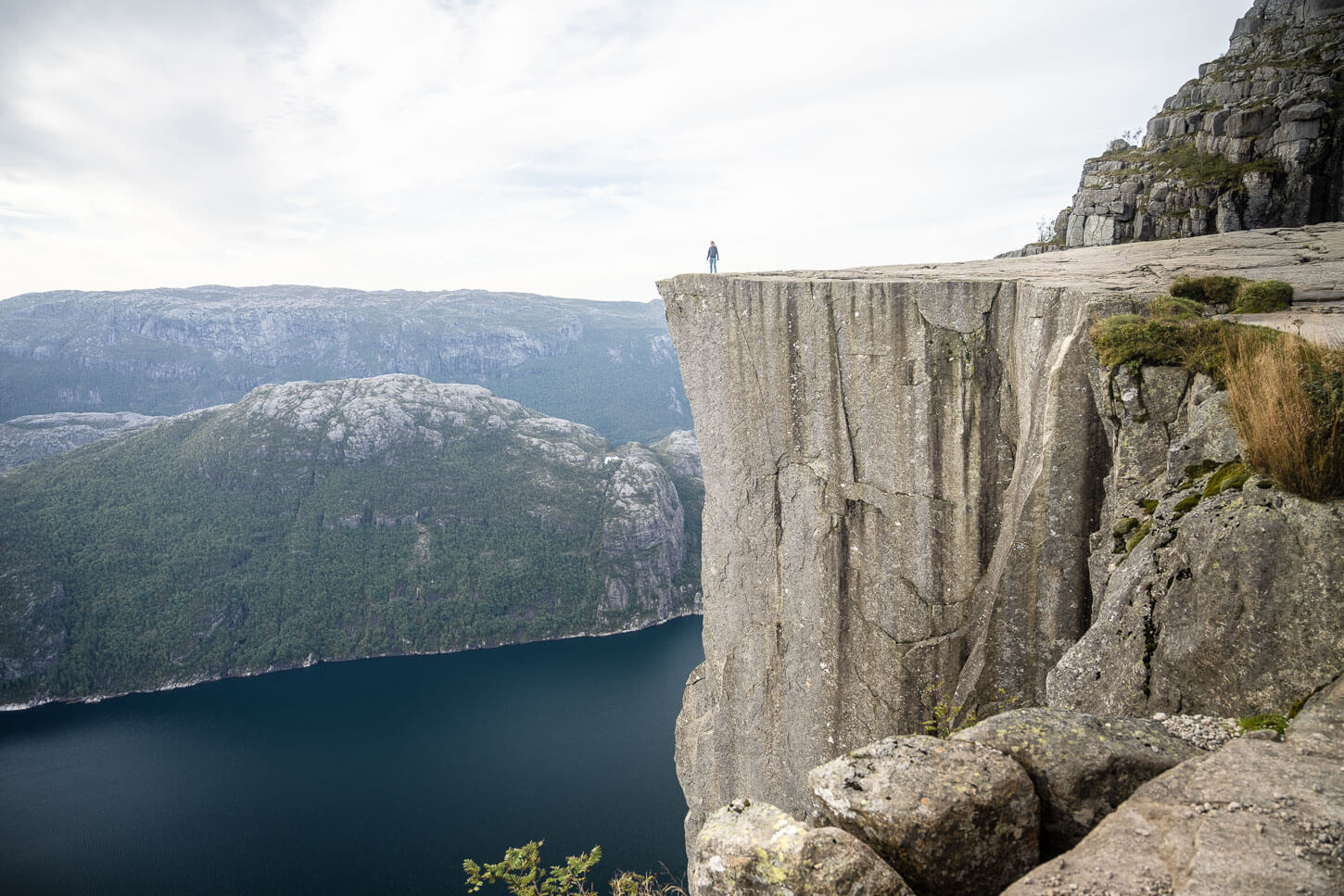 Hiker on top of the Pulpit Rock or Preikestolen watching the landscape.