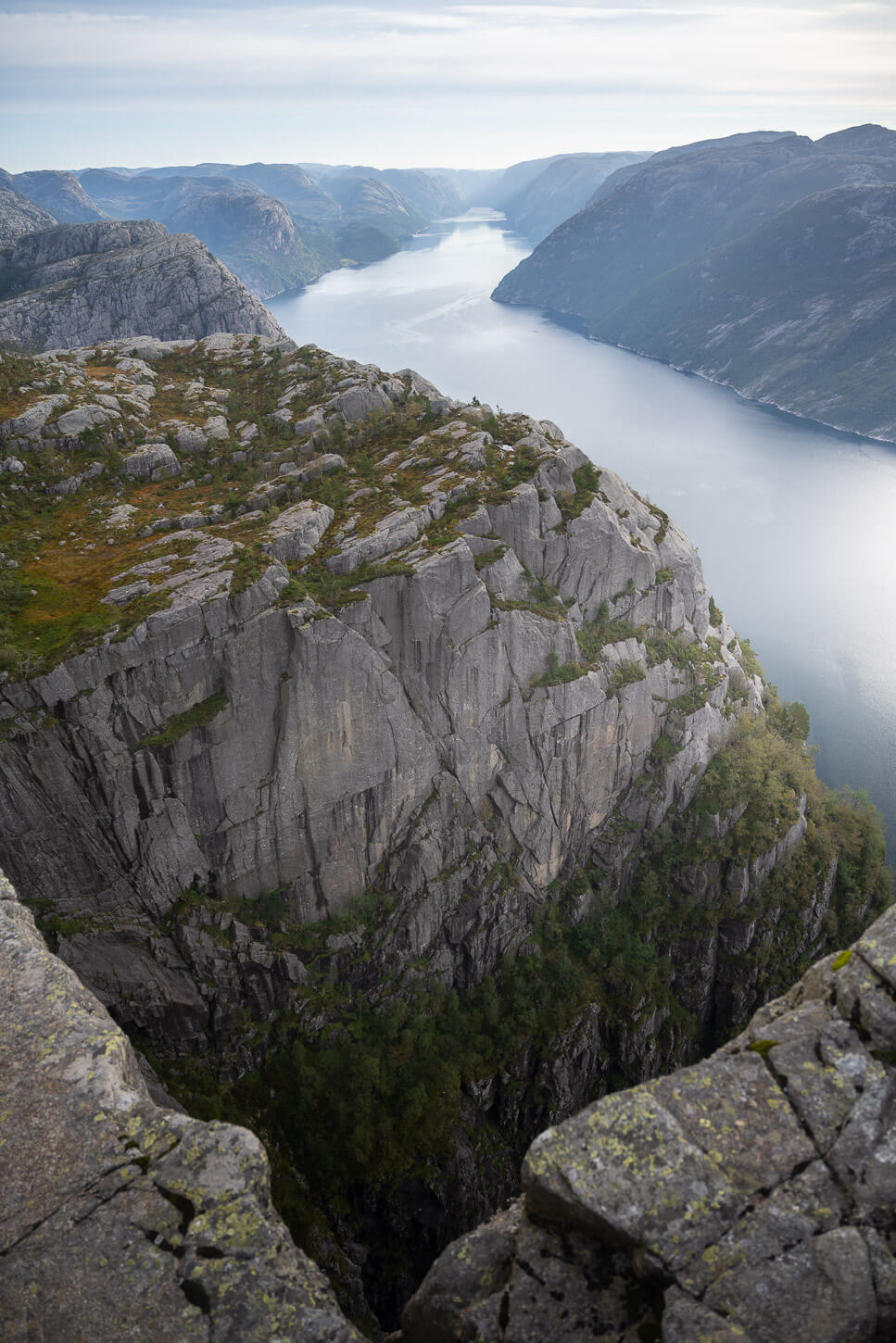 View of Lysefjord from the top of Preikestolen from an exposed rock ledge.