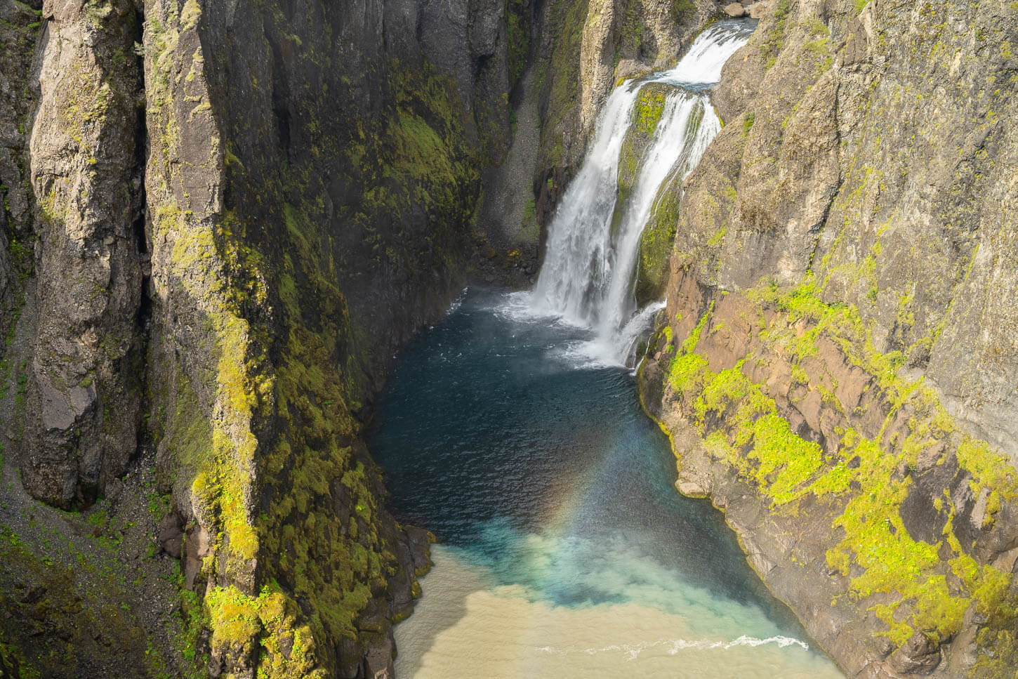 Hvítárfoss with a small rainbow in front of it.