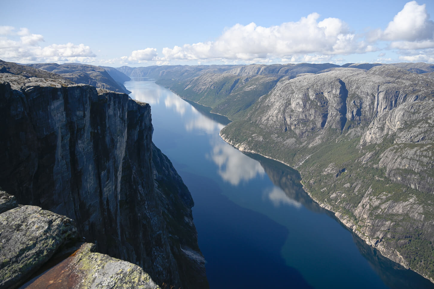 View of Lysefjord from the Nesatindane viewpoint on a sunny day with blue skies.