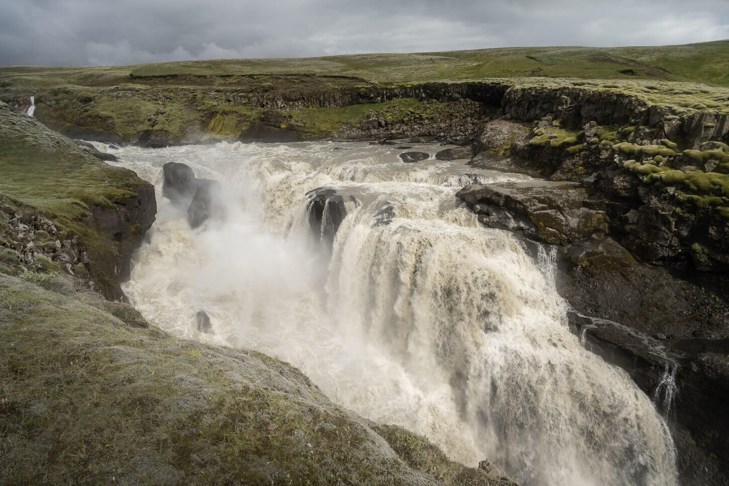Waterfall in an ancient moss-covered lava field